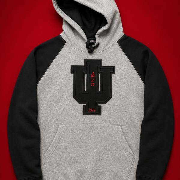 Custom grey and black raglan two-tone pullover hoodie with black PVC patch insignia and crimson Greek letter abbreviations and founding year on front chest.